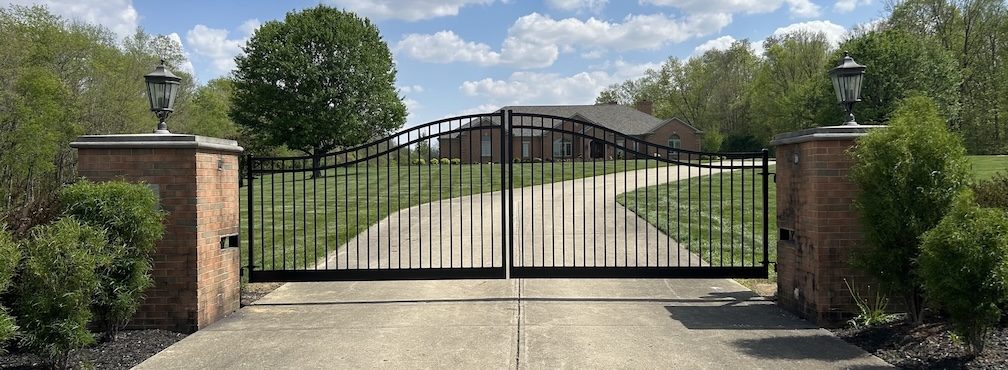 Swing Gate shown closed at entrance to long driveway with house
